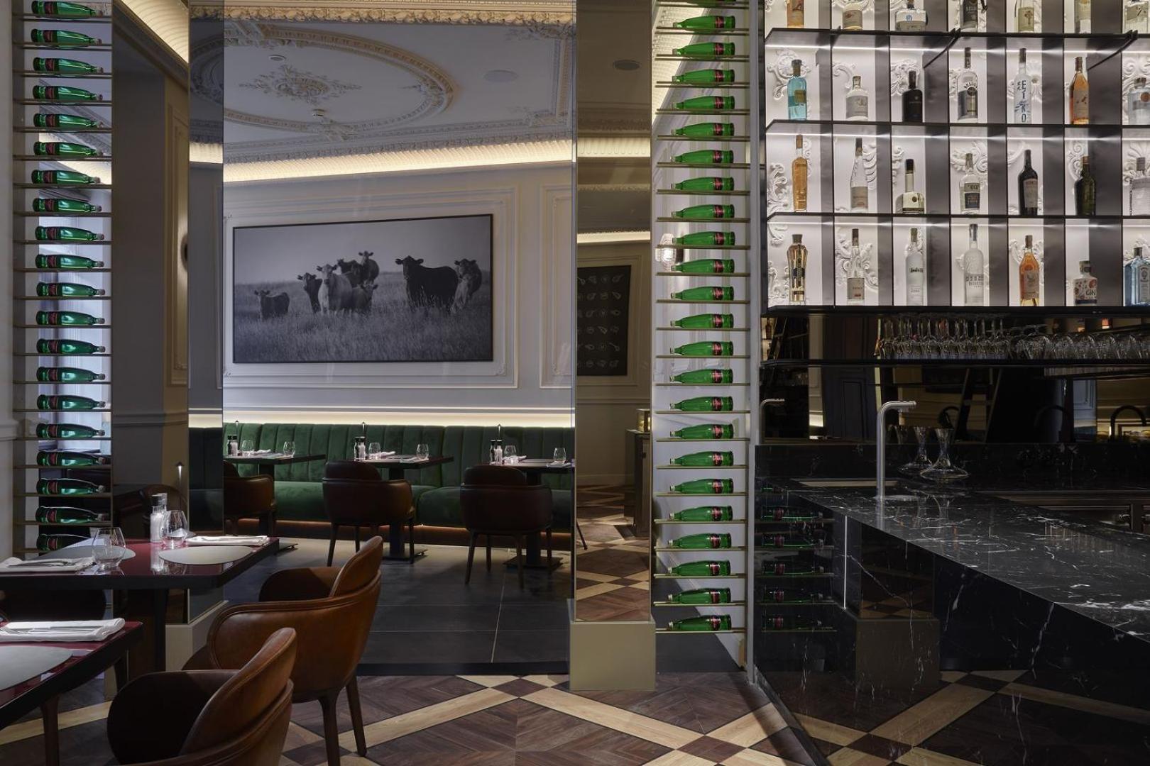 Grandhotel Pupp Karlovy Vary Esterno foto The photo shows the interior of a stylish restaurant. There is a large photograph of cows on the wall, adding a rustic touch to the decor. The space features elegant seating with dark brown chairs, and the tables are set for dining. A bar area is vis